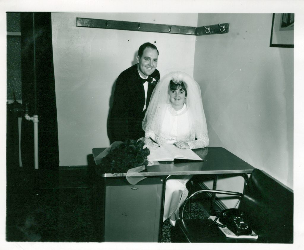 Ray and Meta Norman signing the register during their wedding (1966)